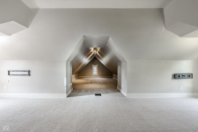 bonus room featuring vaulted ceiling and light colored carpet