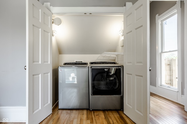 washroom with light wood-type flooring and washing machine and clothes dryer