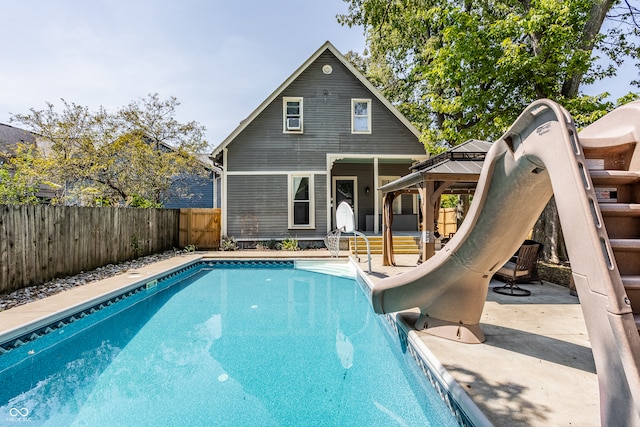 view of swimming pool featuring a water slide, a patio, and a gazebo