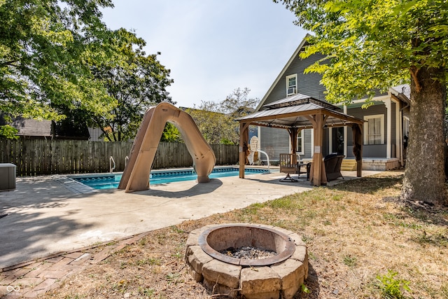 exterior space with a fenced in pool, an outdoor fire pit, a patio, and a gazebo