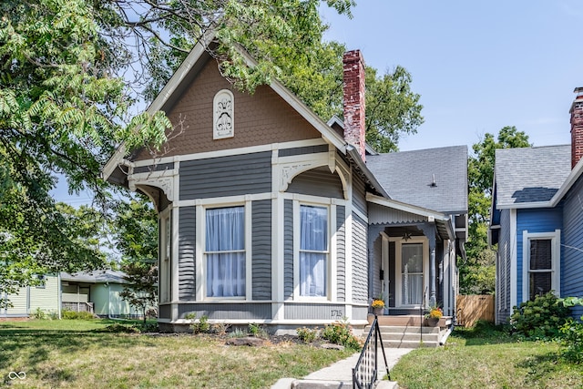 1715 Alabama St, Indianapolis, IN 46202 - view of front of property with a chimney, a front lawn, fence, and a shingled roof