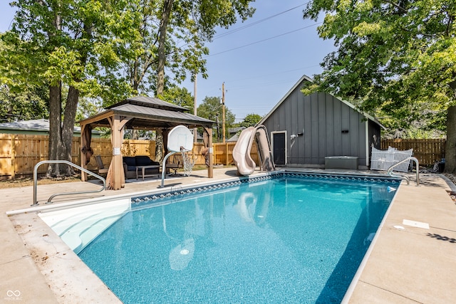 view of pool with a water slide, an outbuilding, a patio, and a gazebo