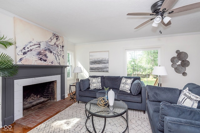 living room with ceiling fan, ornamental molding, and a tile fireplace