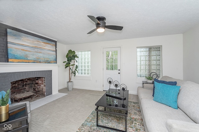 carpeted living room featuring ceiling fan, a textured ceiling, and a brick fireplace