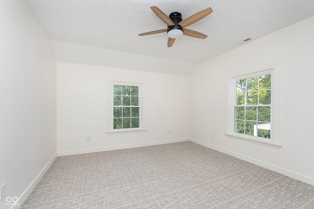 unfurnished room featuring lofted ceiling, carpet, a textured ceiling, and ceiling fan