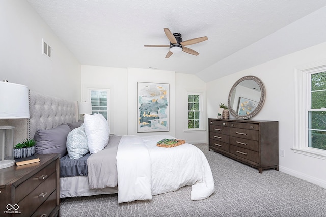 carpeted bedroom with lofted ceiling, a textured ceiling, and ceiling fan