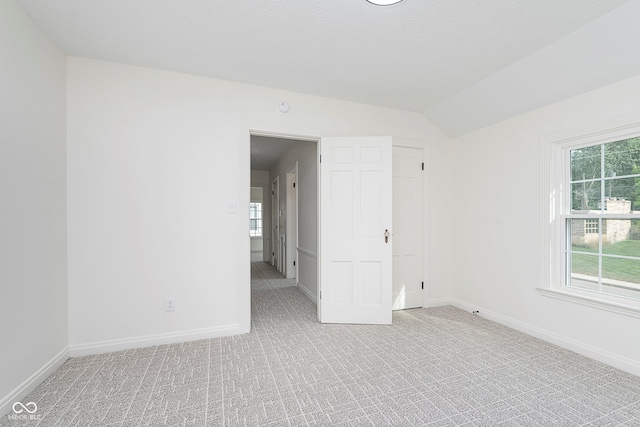 empty room with lofted ceiling and light colored carpet