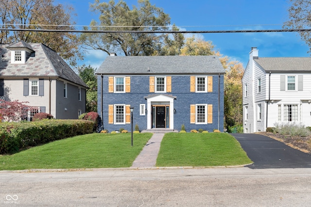 colonial inspired home featuring a front yard