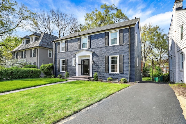 22 W 54th St, Indianapolis, IN 46208 - colonial house featuring brick siding, aphalt driveway, and a front lawn
