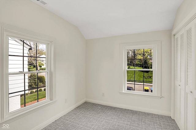 22 W 54th St, Indianapolis, IN 46208 - empty room featuring baseboards, light carpet, a healthy amount of sunlight, and vaulted ceiling