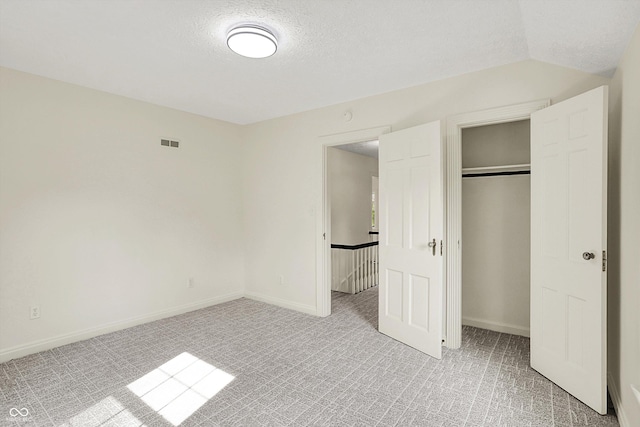 22 W 54th St, Indianapolis, IN 46208 - unfurnished bedroom with light colored carpet, visible vents, a closet, and a textured ceiling