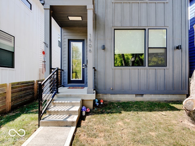 view of exterior entry featuring a lawn