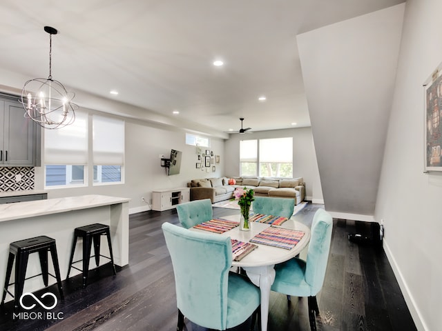 dining area featuring dark hardwood / wood-style floors and ceiling fan with notable chandelier