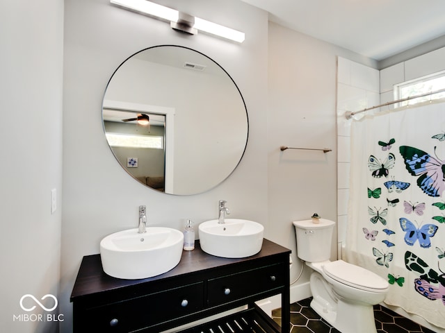 full bathroom featuring tile patterned flooring, vanity, toilet, and shower / tub combo