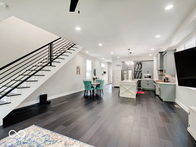 living room with dark wood-type flooring and a chandelier