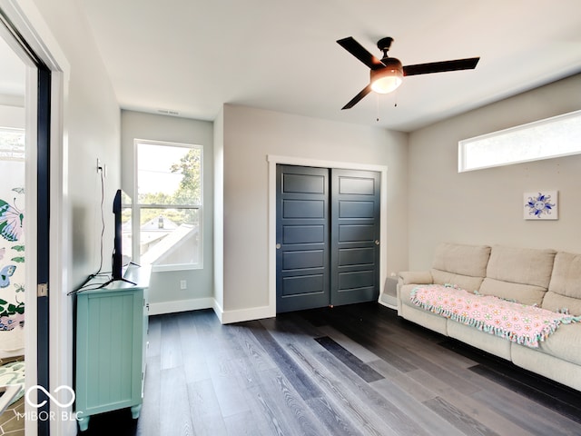 living room featuring ceiling fan and dark hardwood / wood-style floors