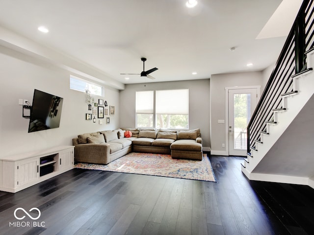 living room featuring ceiling fan and dark hardwood / wood-style floors