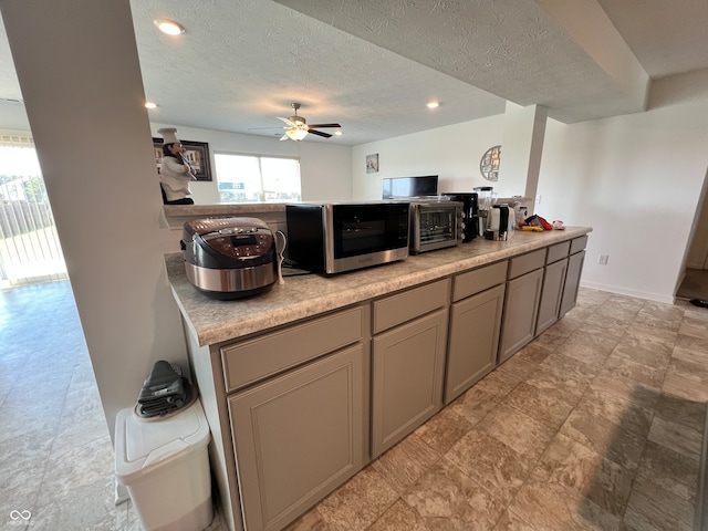 kitchen with ceiling fan and a textured ceiling