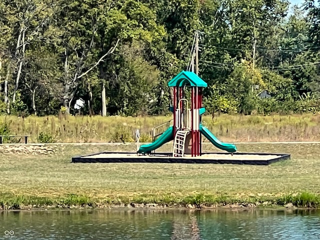 view of jungle gym with a water view and a lawn