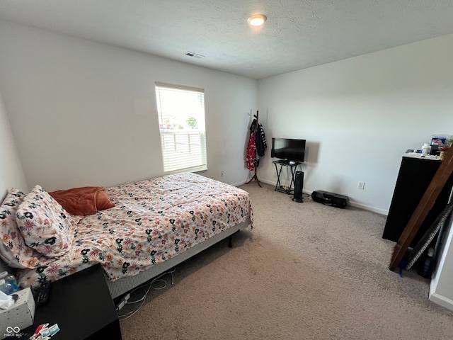 bedroom featuring a textured ceiling and carpet floors