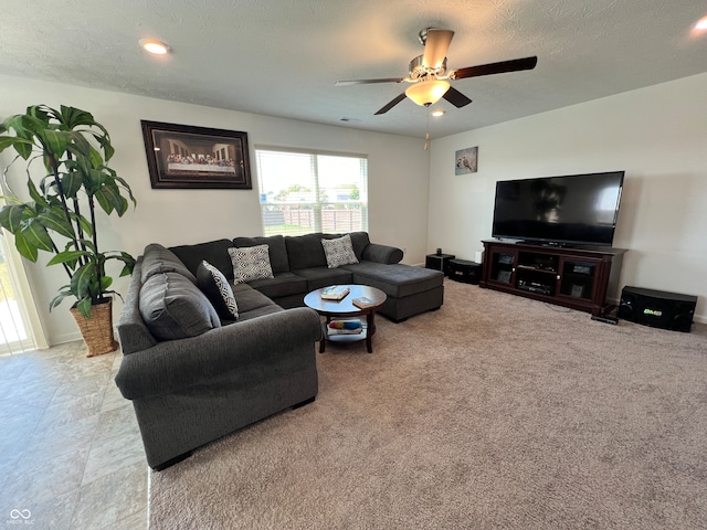 living room featuring ceiling fan and a textured ceiling