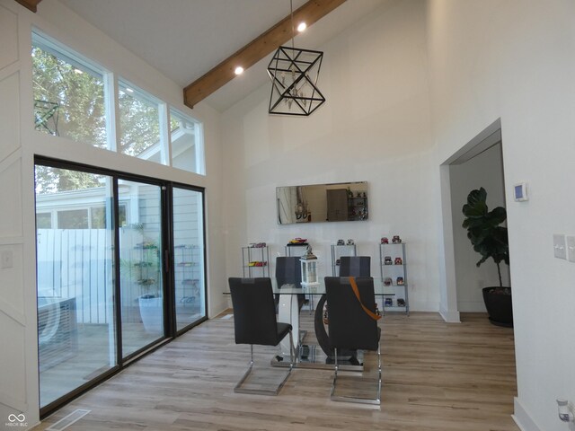 dining area featuring high vaulted ceiling, light wood-type flooring, and beam ceiling