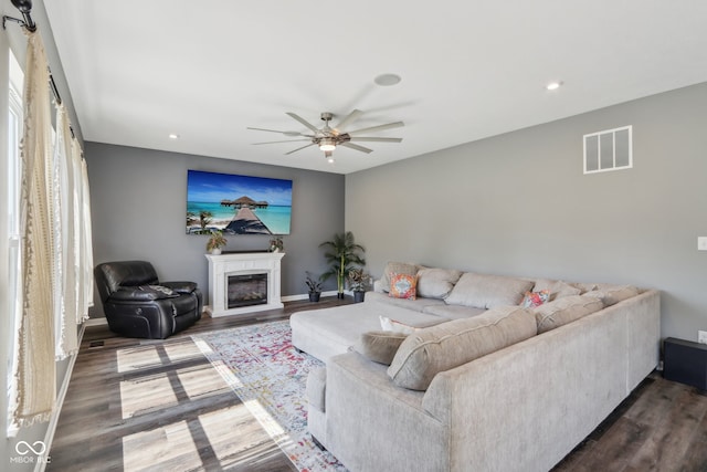 living room featuring ceiling fan and dark hardwood / wood-style flooring