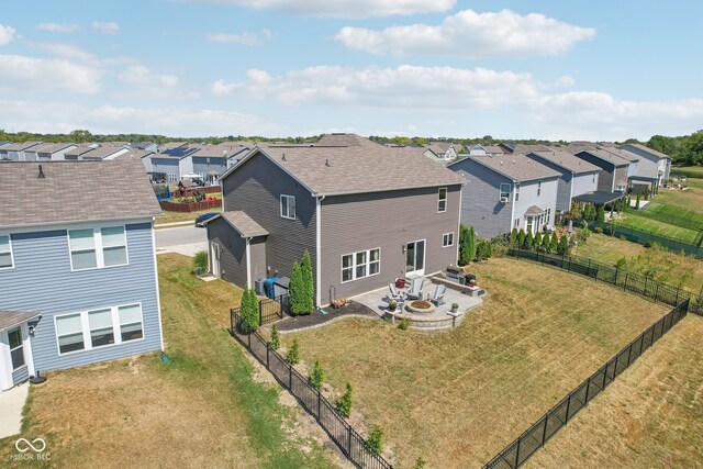 rear view of property with a fire pit, a lawn, and a patio area