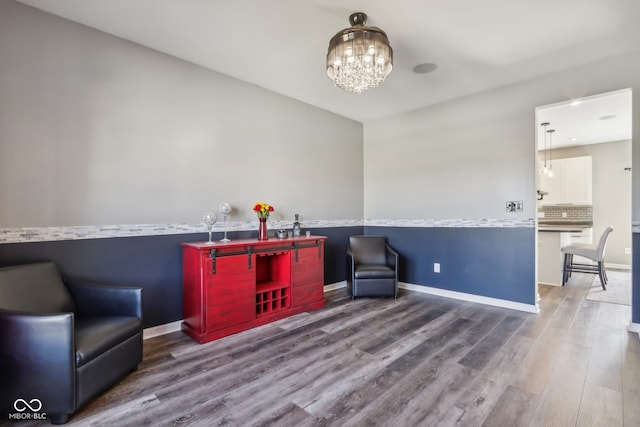 living area featuring hardwood / wood-style flooring and a notable chandelier