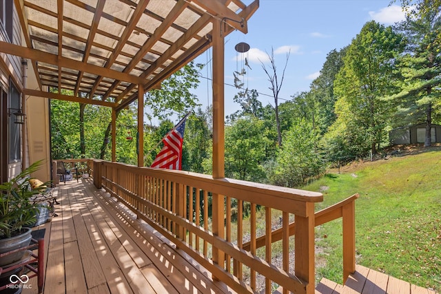 wooden terrace featuring a pergola and a lawn