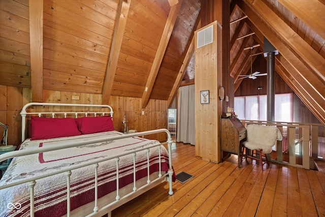 bedroom with wood-type flooring, wooden walls, lofted ceiling with beams, and wooden ceiling