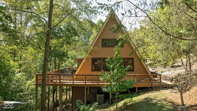 rear view of house featuring cooling unit and a wooden deck