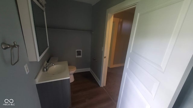 bathroom with vanity, toilet, and hardwood / wood-style floors