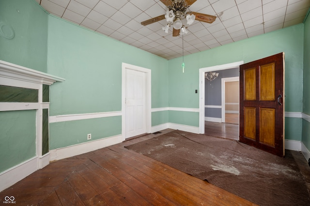 unfurnished bedroom featuring ceiling fan, hardwood / wood-style flooring, and a paneled ceiling