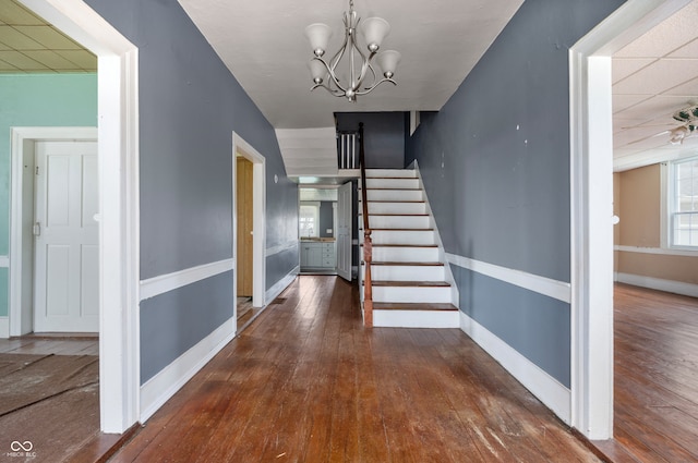 staircase featuring a chandelier and hardwood / wood-style floors