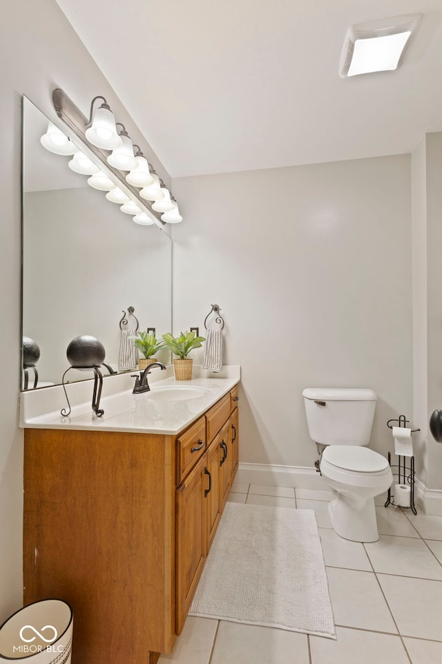 bathroom with vanity, toilet, tile patterned flooring, and baseboards