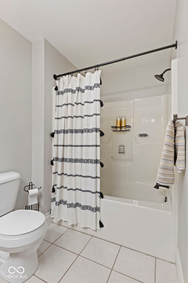 full bath with tile patterned floors, shower / bath combo, toilet, and baseboards