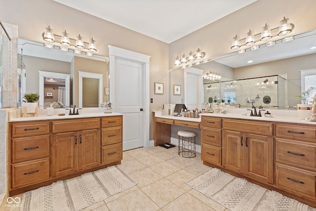 bathroom with tile patterned flooring, two vanities, a sink, and a shower stall