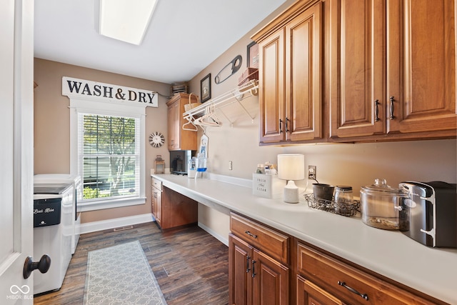 kitchen featuring dark wood-type flooring, built in study area, and brown cabinets