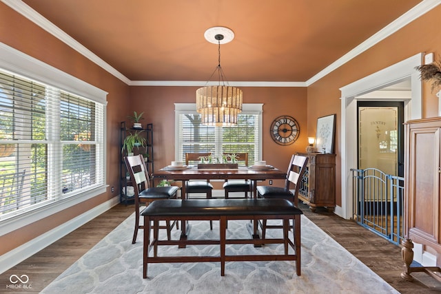 dining area with ornamental molding, an inviting chandelier, and dark wood-type flooring