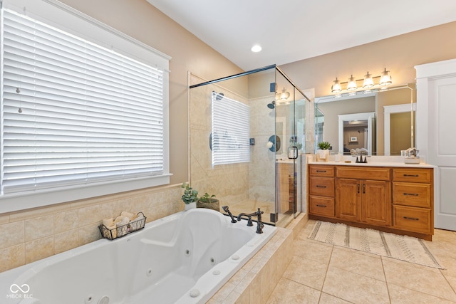 bathroom with a tub with jets, a stall shower, tile patterned flooring, and vanity