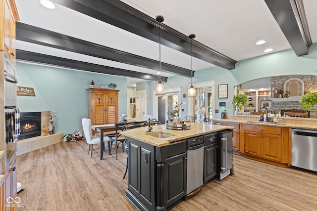 kitchen featuring stainless steel appliances, a sink, and a lit fireplace