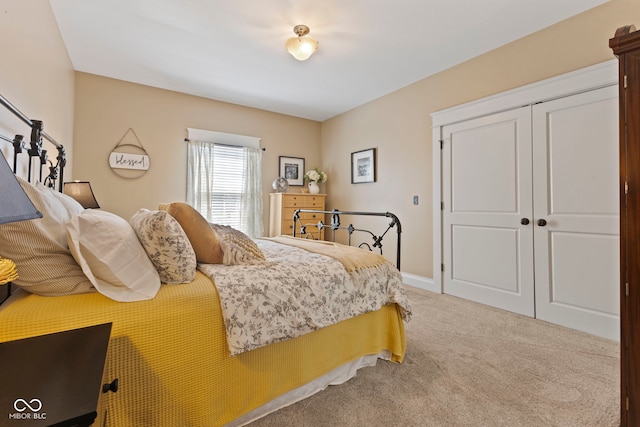 carpeted bedroom featuring baseboards and a closet