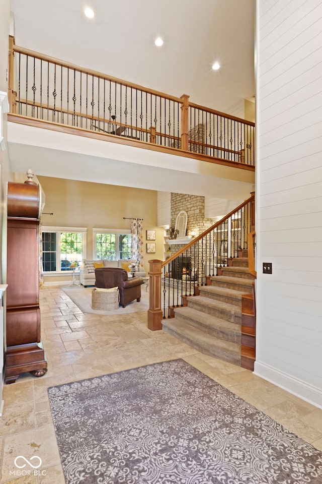 living room with a towering ceiling, stairs, and recessed lighting