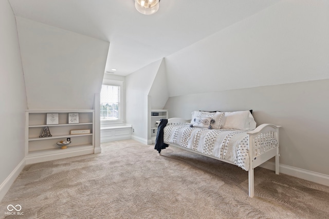 carpeted bedroom with lofted ceiling