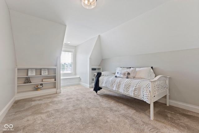 carpeted bedroom with baseboards and lofted ceiling