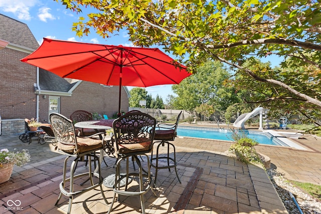 view of patio / terrace featuring outdoor dining space and a fenced in pool
