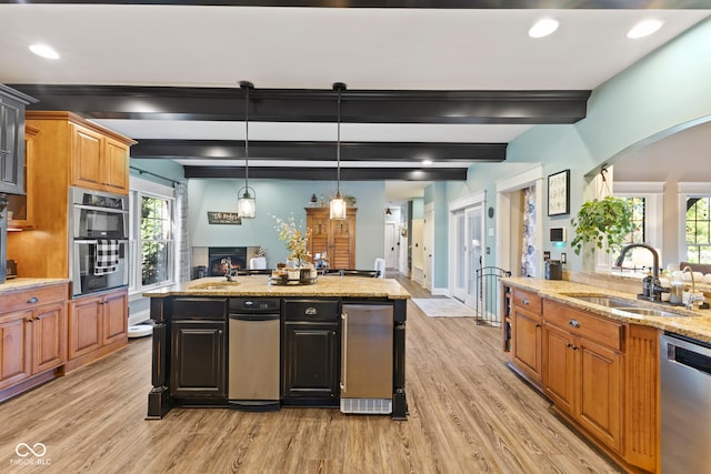 kitchen with light wood-type flooring, stainless steel appliances, arched walkways, and a sink