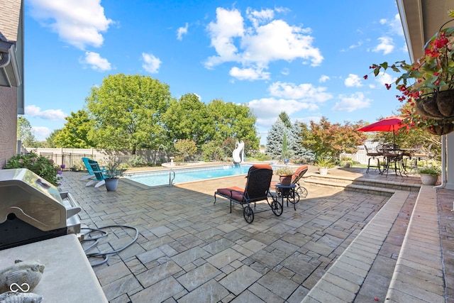 view of patio featuring a fenced in pool and a grill