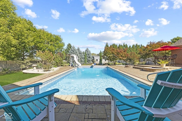 view of swimming pool with a patio, a fenced in pool, a water slide, and fence